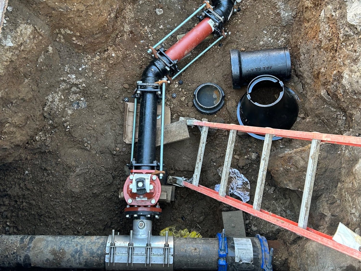 Underground pipe and valve installation in excavated trench